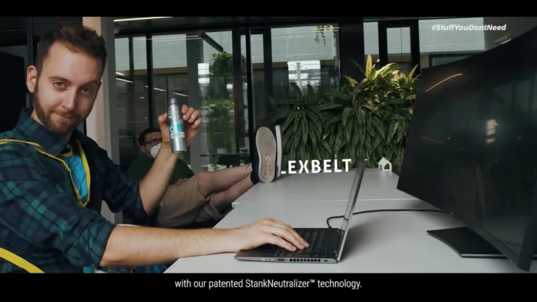 Still image from Flexbelt video showing office worker smiling at camera holding can of deodorant.